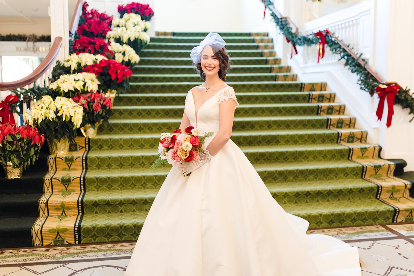 Bride in a satin ballgown and a birdcage veil with a red lip