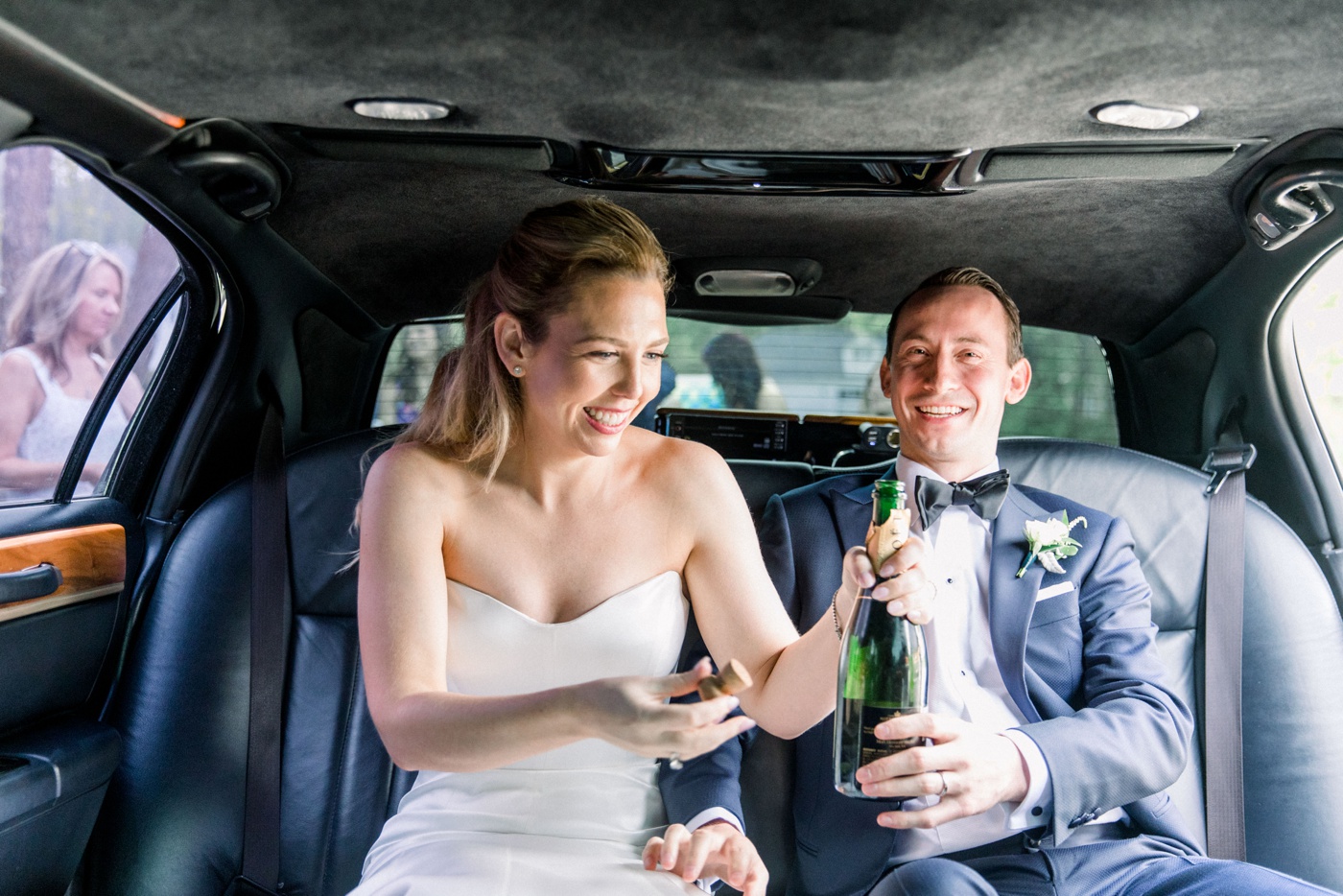 Bride and groom in a limo with champagne after their wedding ceremony