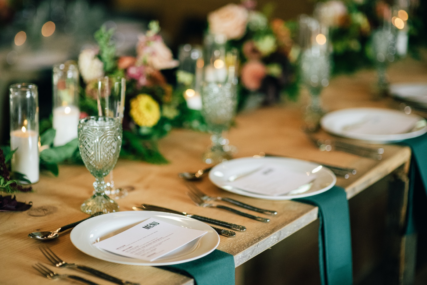 Turquoise linens and colorful floral centerpieces by Dutch Bloemen Winkel at a backyard wedding in NH