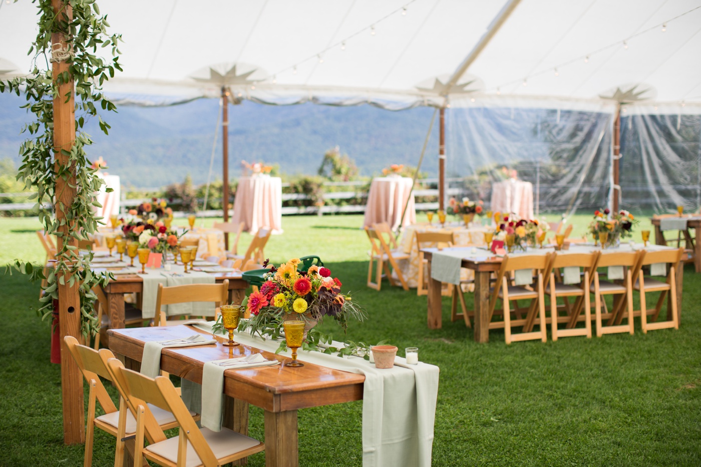 Sage linens, vintage amber goblets, and colorful floral centerpieces for a fall wedding reception