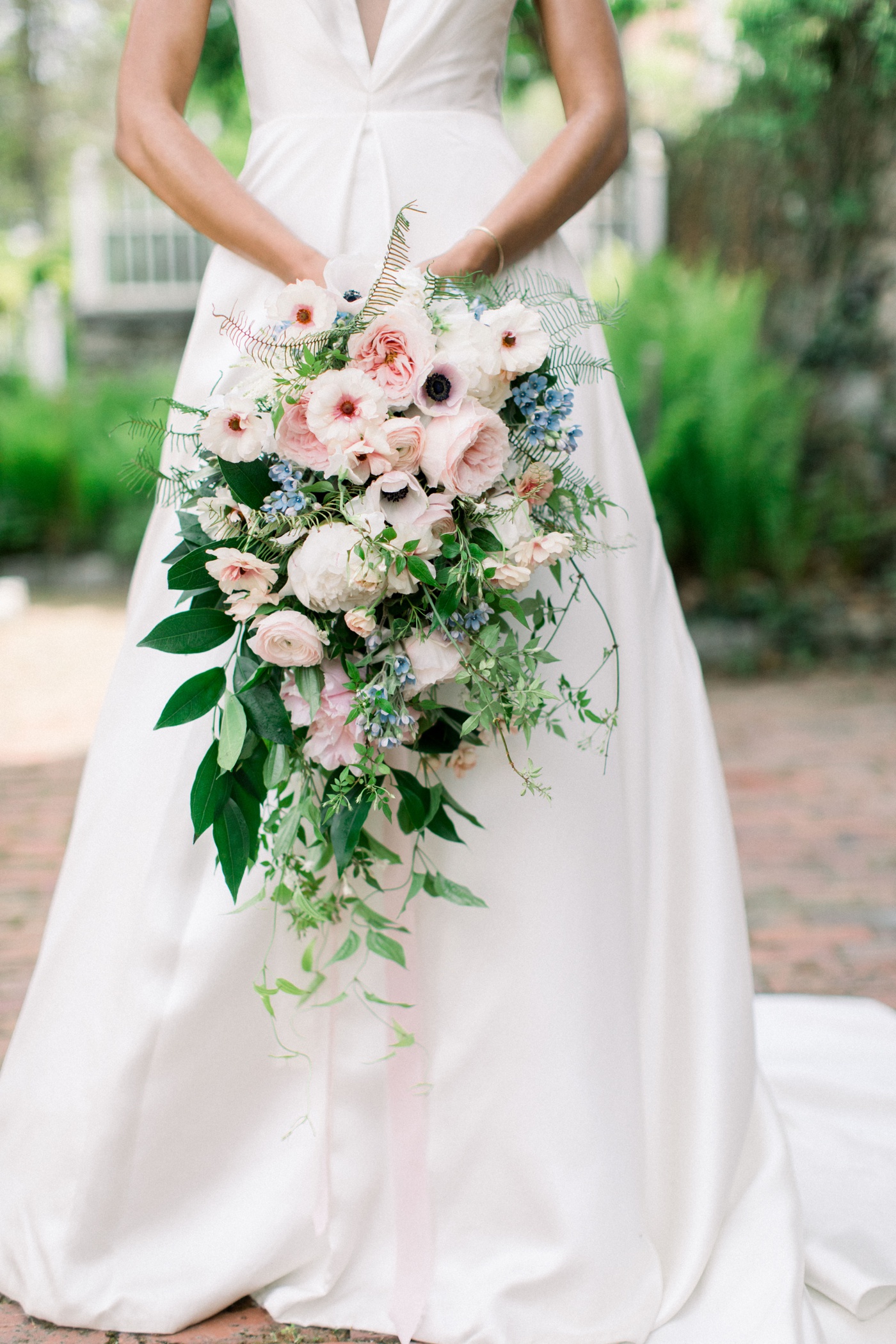 Blush wedding bouquet filled with anemones, garden roses, and butterfly ranunculus by Emily Herzig