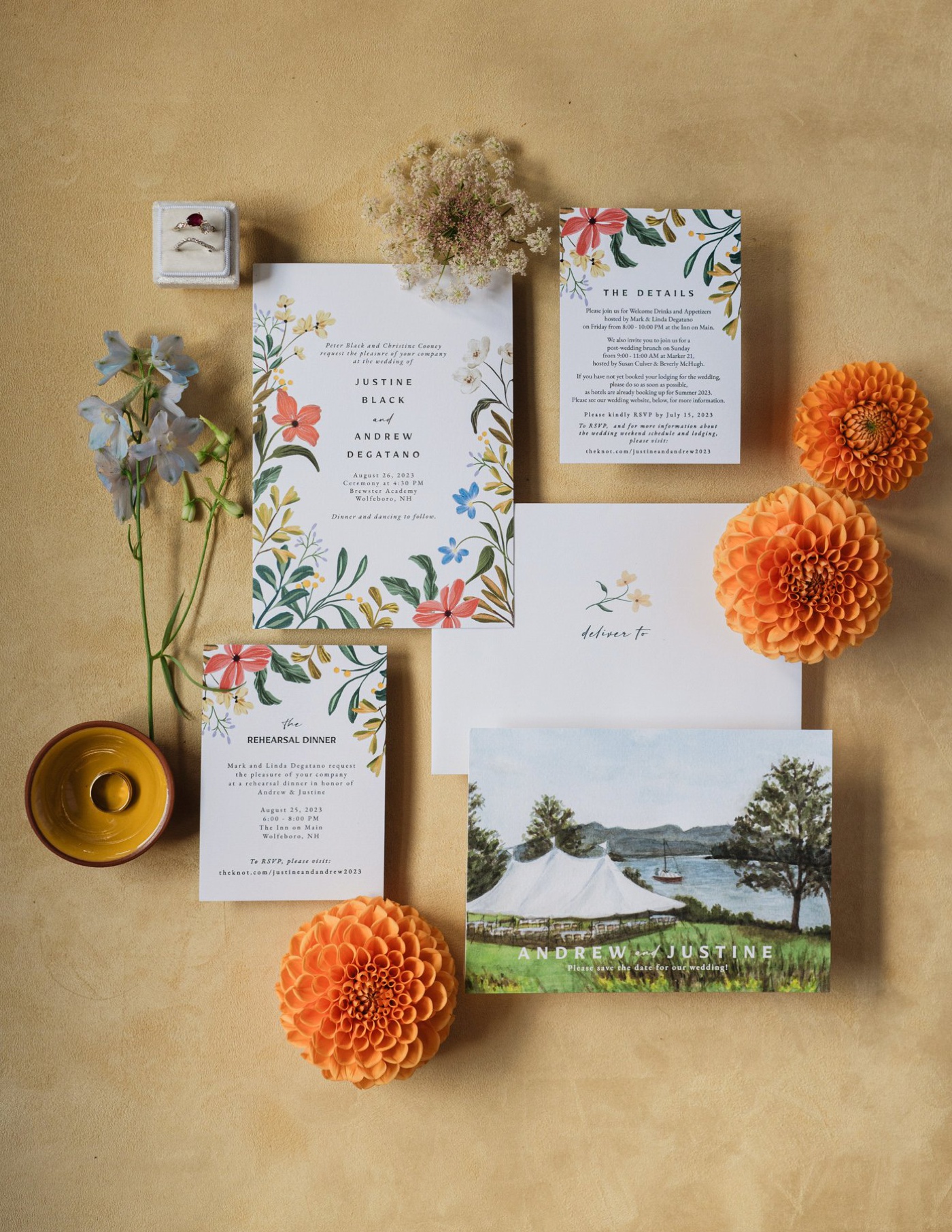 Flatlay of a botanical wedding invitation with orange dahlias