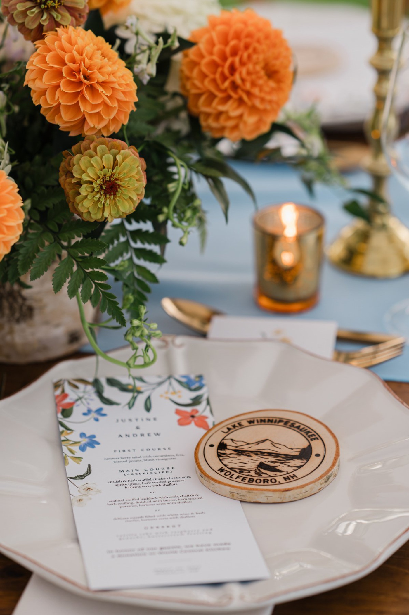 Summer wedding table with light blue linen and orange flowers